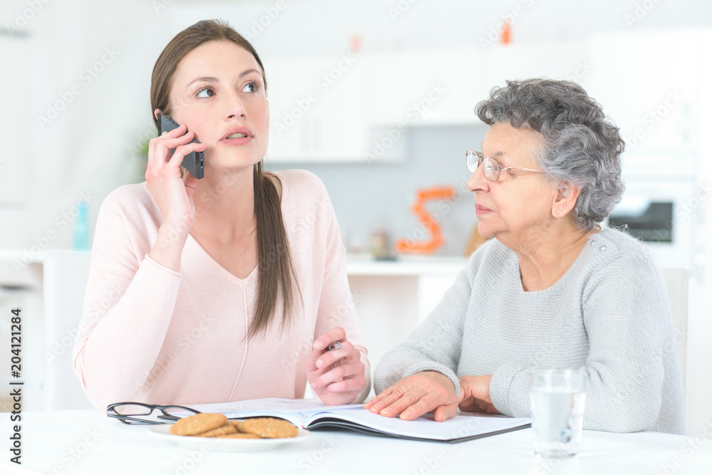 daughter and elderly mother making a phone call daughter and elderly mother making a phone call