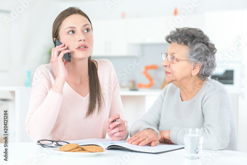daughter and elderly mother making a phone call