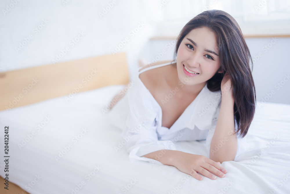 sexy woman is lying on her bed and look at camera in the morning