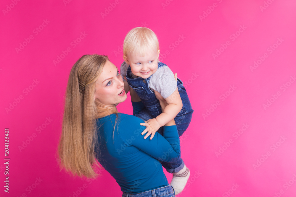 young mother and daughter having fun together on pink background young mother and daughter having fun together on pink background