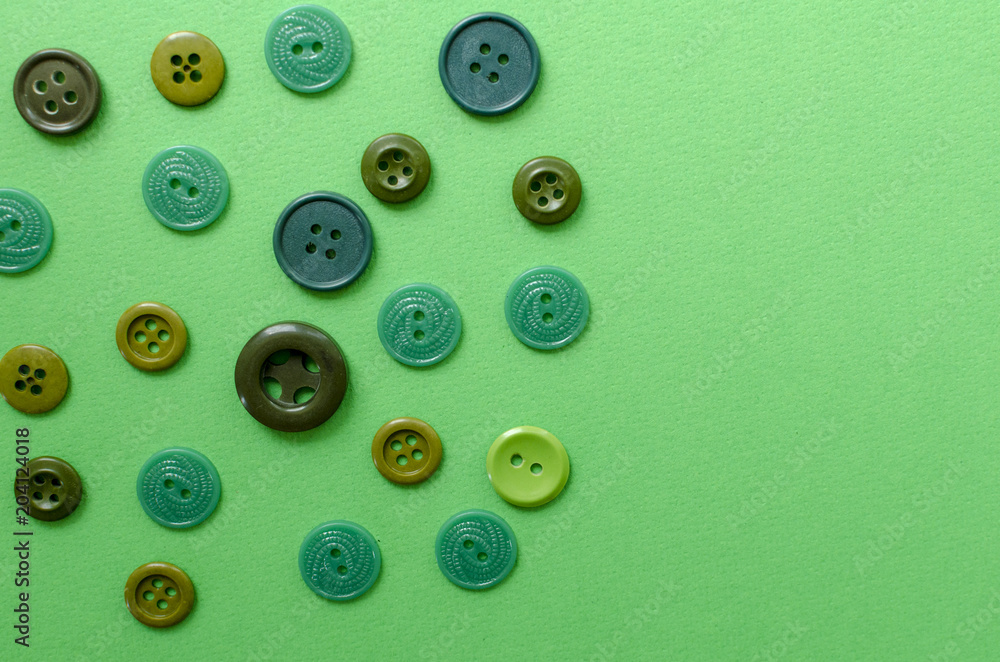 Green plastic buttons on green paper background Green plastic buttons on green paper background