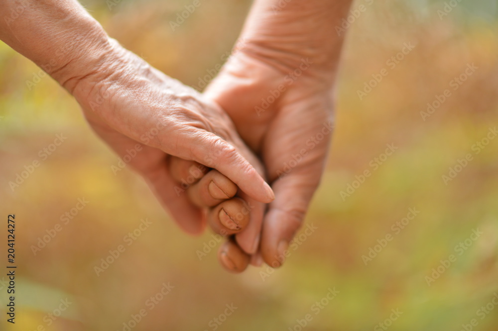 Elderly couple holding hands together Elderly couple holding hands together