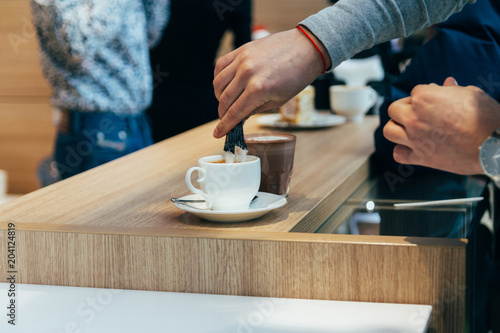 man hands pouring sugar to the latte cup in cafe