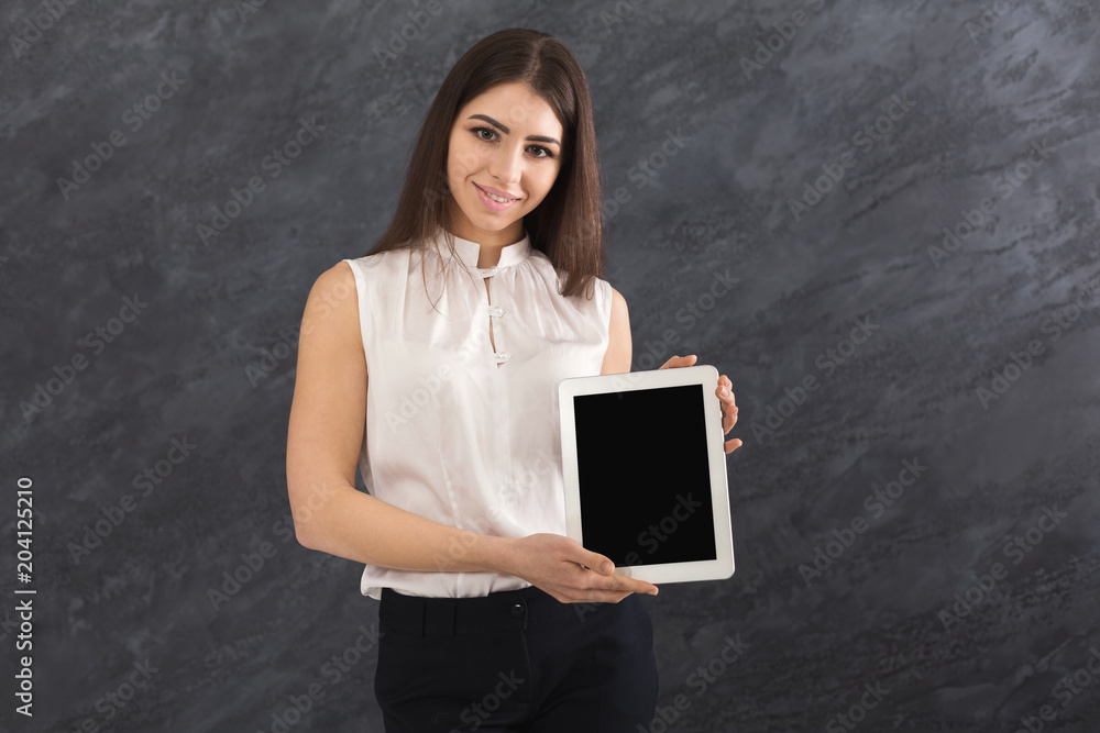 Happy woman showing digital tablet on grey background Happy woman showing digital tablet on grey background