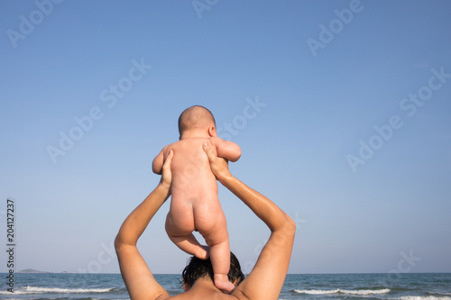 Father and infant Son playing at the beach.
