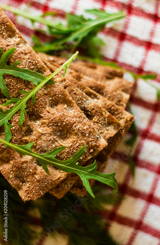 Crispbread with ruccola on tablecloth in red cage photo