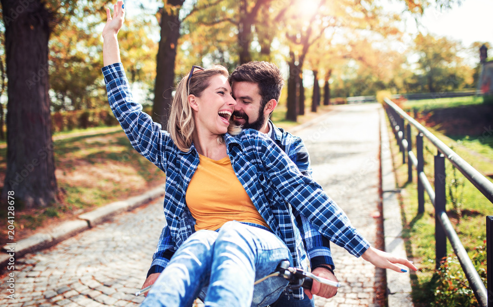 Fototapeta premium Couple in love. Romantic couple riding a bicycle in the park. Love, dating, romance