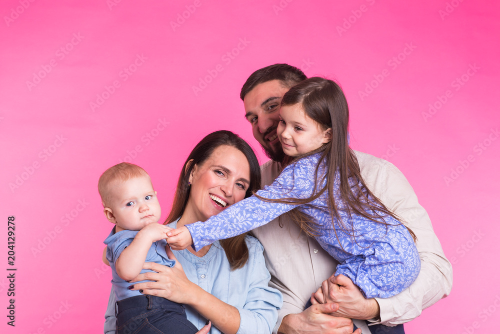 Portrait of Young Happy Mixed Race Family over pink background.