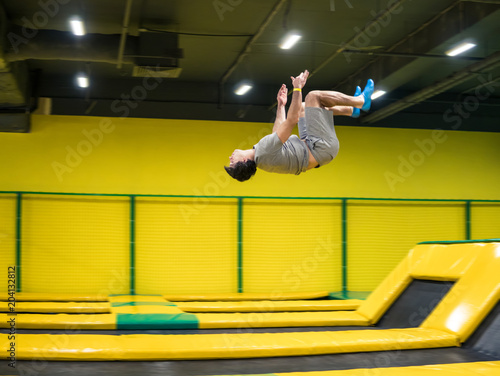 Quadro su tela trampoline jumper performs complex acrobatic exercises and somersault on the trampoline