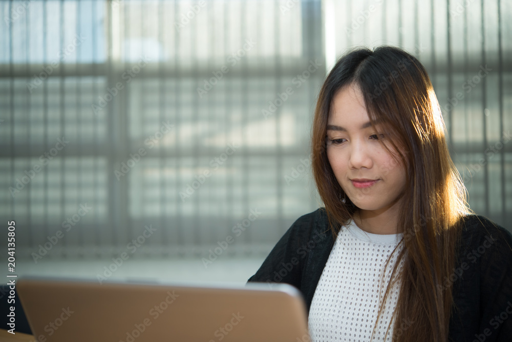 Fototapeta premium Beautiful asian woman working at the office in the evening,Thailand worker writing book in the company