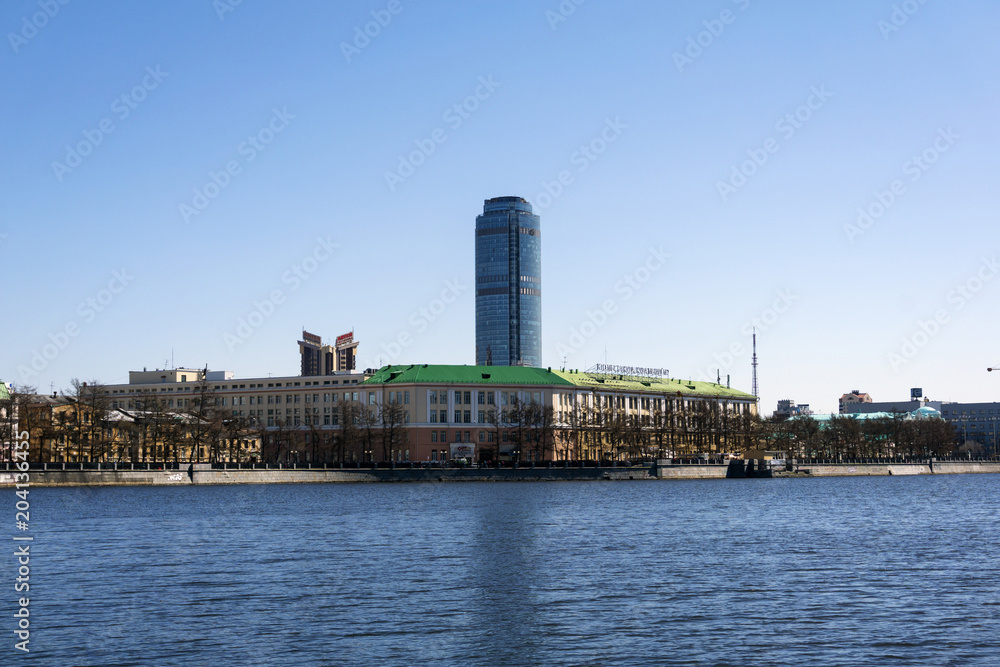 Fototapeta premium Yekaterinburg, Russia - May 02, 2018: city landscape and view of the Vysotsky tower from the waterfront of the City pond..