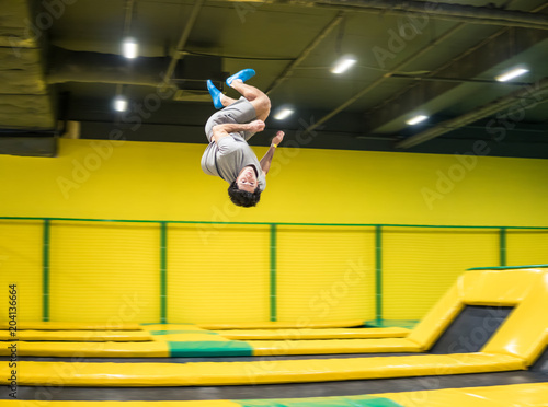Foto trampoline jumper performs complex acrobatic exercises and somersault on the trampoline
