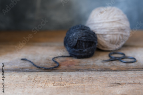 Beige and Grey yarn balls with scissors background, blurred selective focus