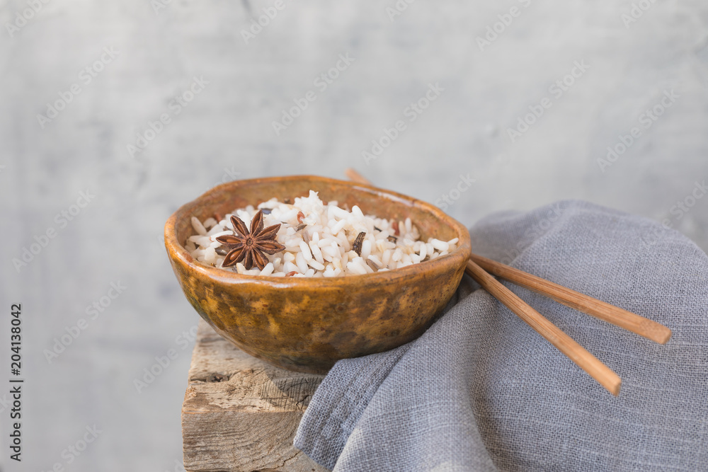 Fototapeta premium Bowl with wild brown mixed rice on the wooden background, wabi sabi style