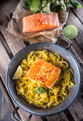 Pieces of roasted salmon with pasta tagliatelle lemon and basil