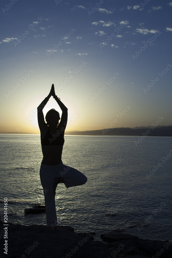 Beauty girl on beach in yoga pose, relax silhouette