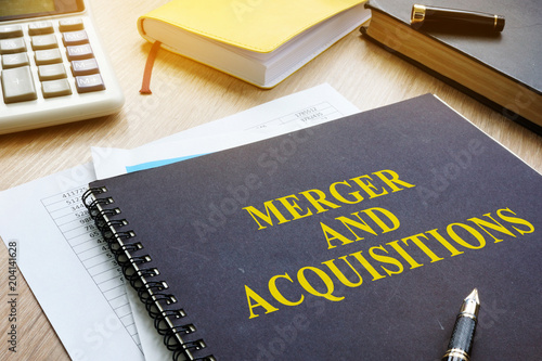 Book about Merger And Acquisitions M&A on a desk. photo