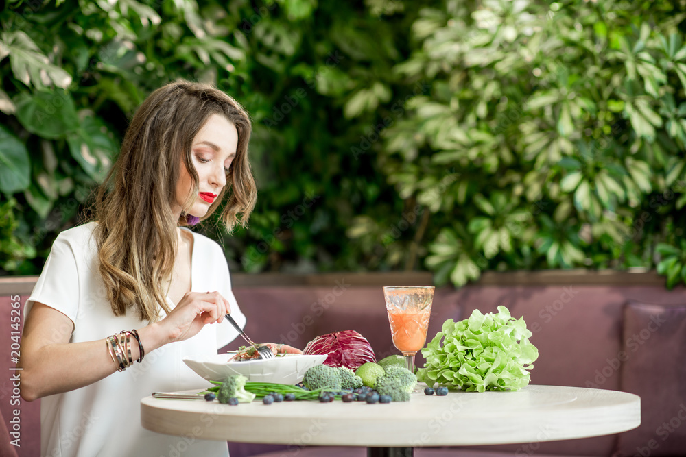 Woman with healthy food on the green wall background