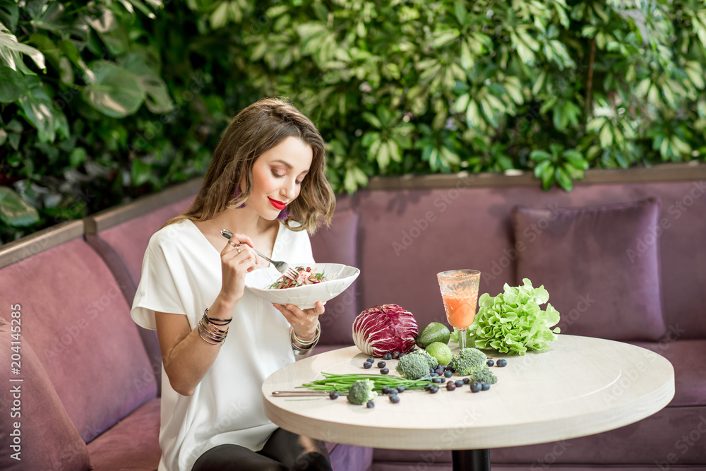Woman with healthy food on the green wall background Woman with healthy food on the green wall background
