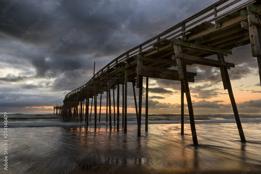 Fishing Pier with Colorful Sunrise and Dramatic Sky