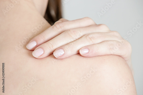Studio shot of young woman with neck pain