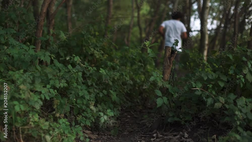 SLOW MOTION: Close up male running through the woods 4k SLOW MOTION: Close up male running through the woods 4k