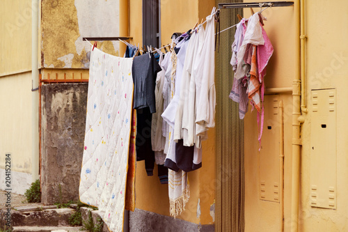Dry clothes on clothesline, drying things on the street on the balcony of the house © Vladyslav