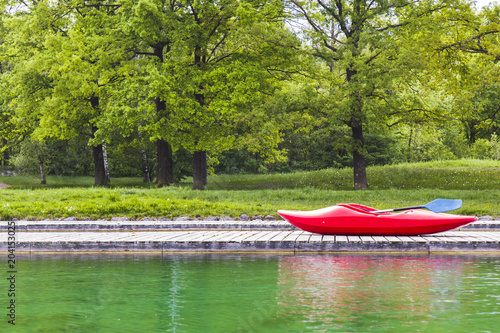 A red kayak on wooden jetty in a Lake