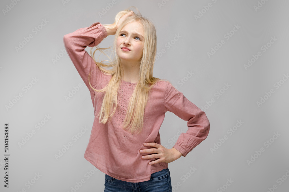 Beautiful teen girl with white long hair. A teenager stands and holds his hair with his hand Beautiful teen girl with white long hair. A teenager stands and holds his hair with his hand