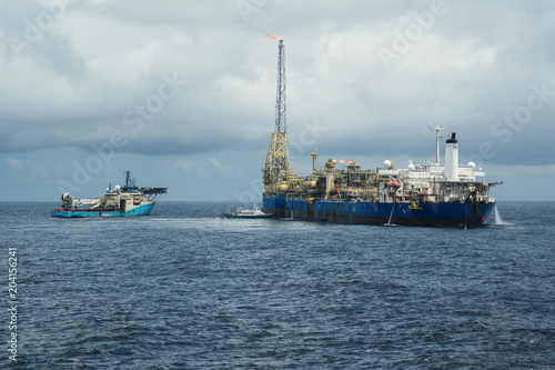 DP operations near FPSO tanker. Supply fleet job, DSV diving support vessel is approaching. Crewboat is coming for crewchange. Oil and gas research and production industry. © Igor Kardasov