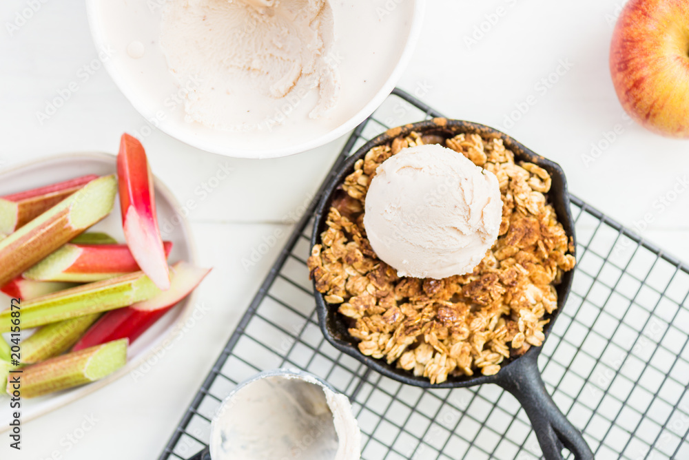 Homemade cooked rhubarb and apple crumble with oatmeal and vanilla ice cream Homemade cooked rhubarb and apple crumble with oatmeal and vanilla ice cream