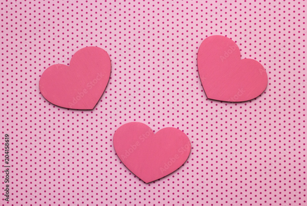 pink polka dots background and hearts from wood