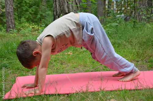 Baby doing yoga exercises. Downward Facing Dog pose. Adho Mukha Svanasana photo