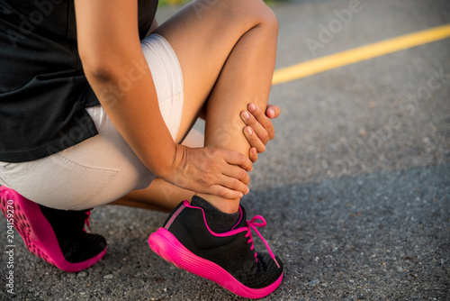 Ankle sprained. Young woman suffering from an ankle injury while exercising and running. Healthcare and sport concept.