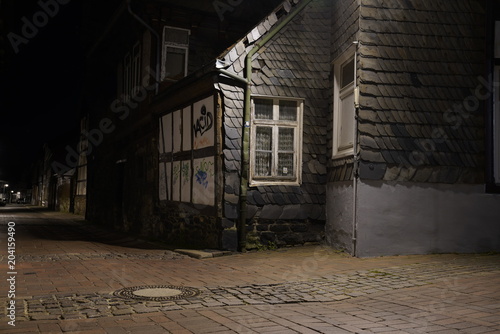  Tiny street with old nordic style houses at night in the town of Goslar, Germany in the Harz region.