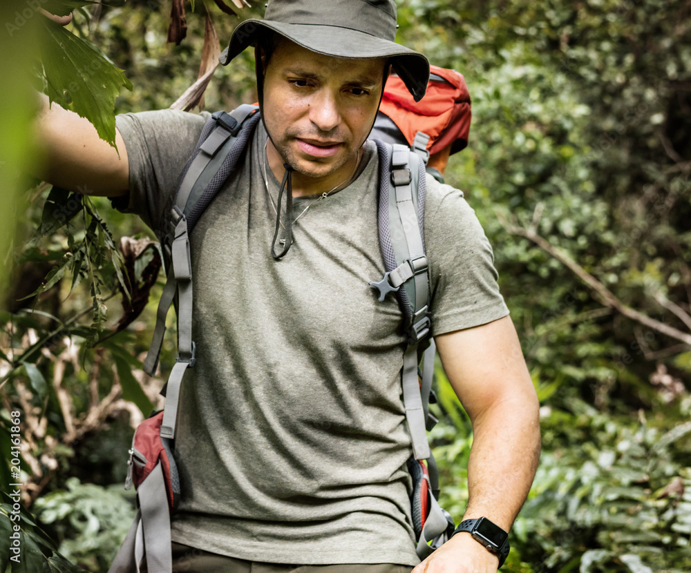 Male backpacker trekking in the forest