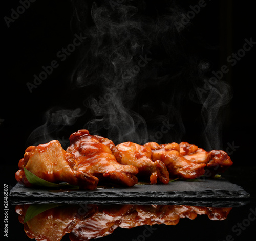 Schilderij op canvas Hot and spicy bbq chicken wings with dip and hot sauce on black stone plate