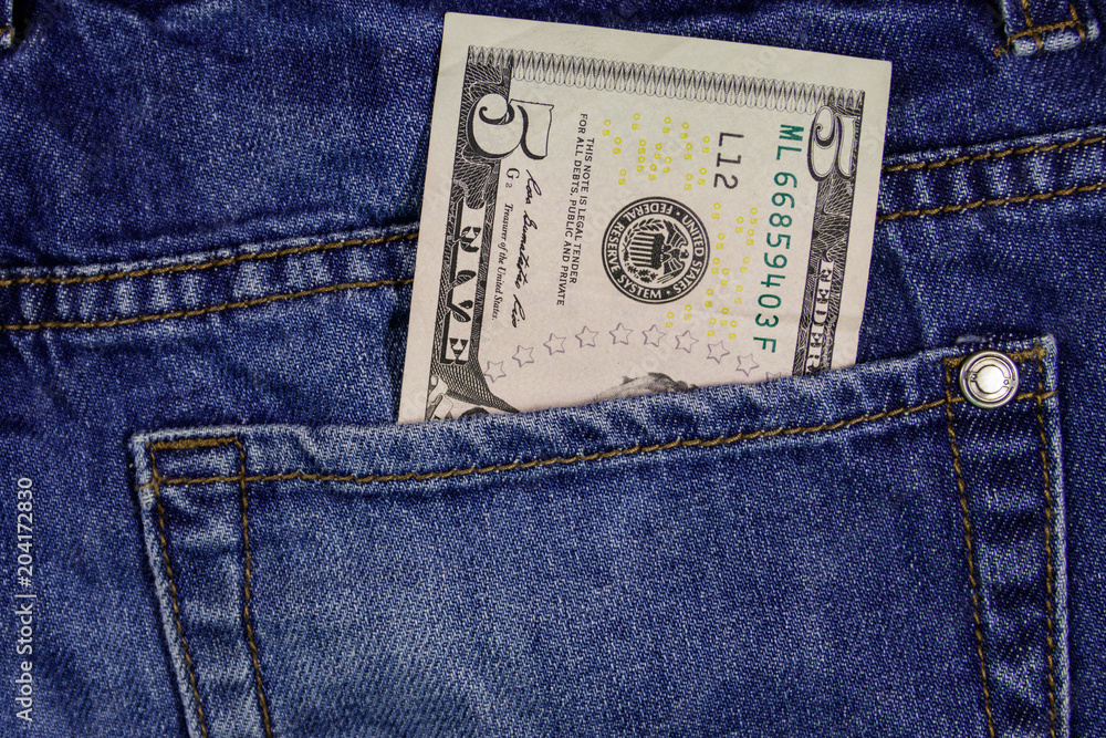 Five dollars banknote in the pocket of blue jeans Five dollars banknote in the pocket of blue jeans