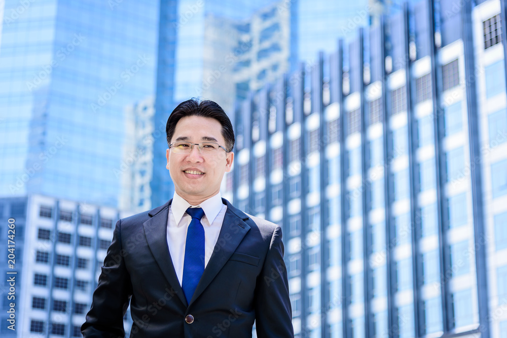 The asian businessman has thinking of vision with building and city background. The asian businessman has thinking of vision with building and city background.