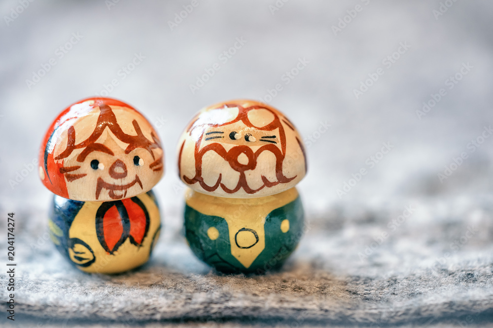miniature souvenir grandparents in the form of traditional Russian matryoshka standing together in a gray knitted background with copy space.