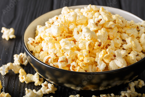 Popular snack: salted popcorn with cheddar cheese and parmesan in a bowl close-up. horizontal