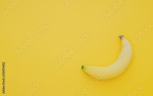 One ripe sweet testy banana on yellow background top view with copy space