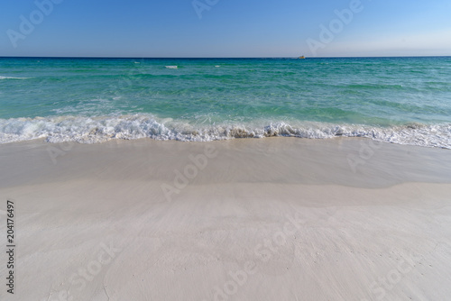 Gulf of Mexico emerald green and blue water washing on shore in waves