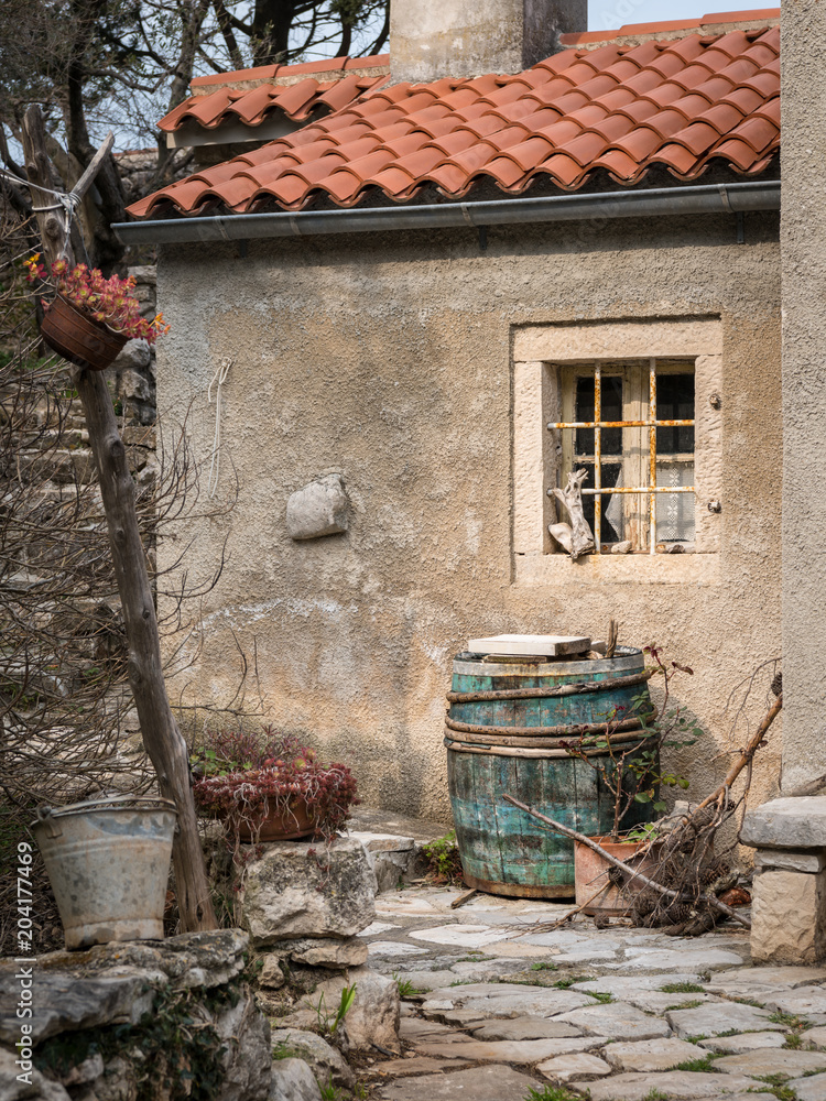 Naklejka premium Wine barrel in front of an old house in Valun