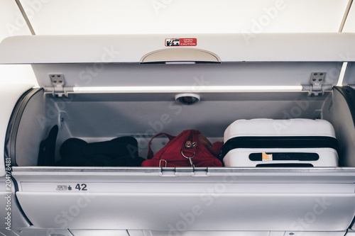 Luggages in the airplane overhead bin. 