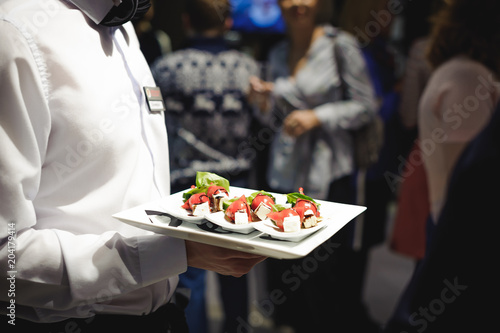 Waiter carrying trays with food. Caterring service for wedding, birthday or any company event