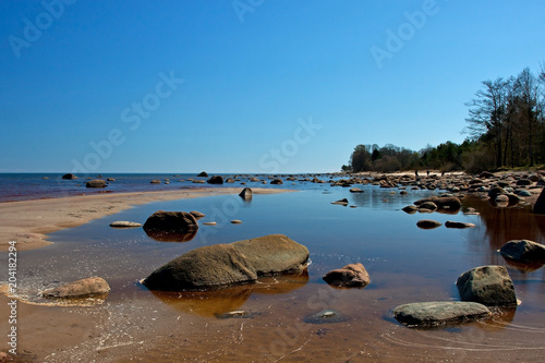 Sunlight day on the sea with  big stones on coast photo