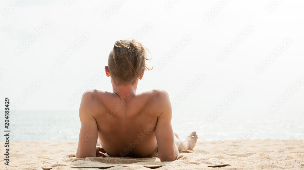 Young man lying on the beach in summer Young man lying on the beach in summer