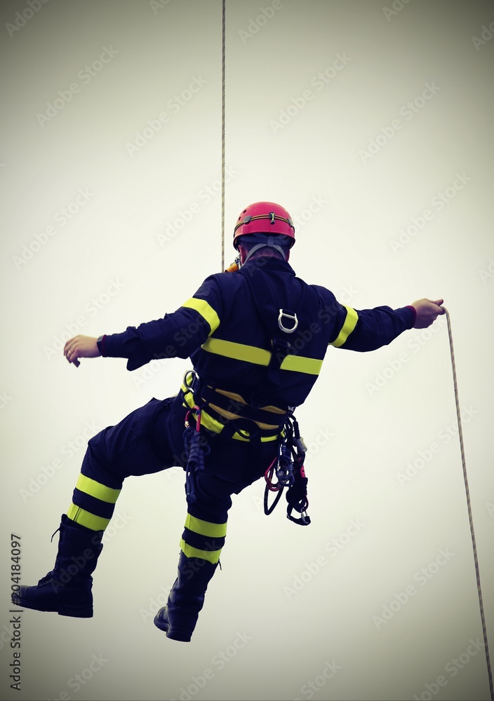 Obraz premium fireman hanging from a cord suspended with vintage effect