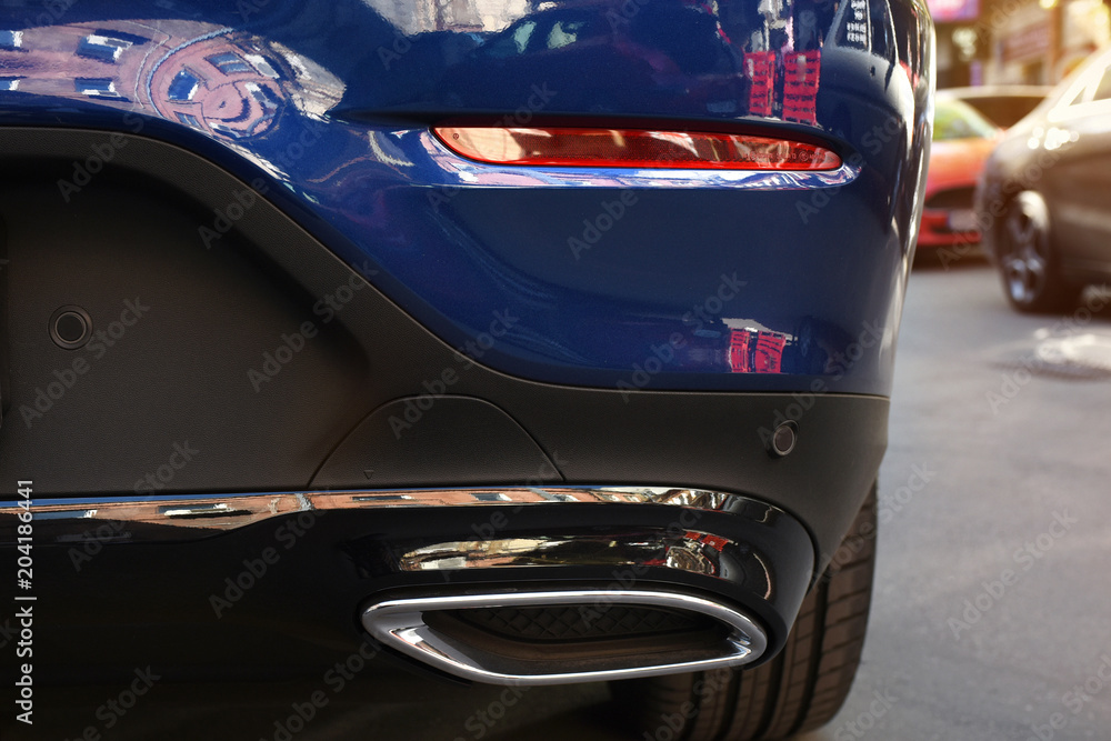 Exhaust pipe of the sports car close up standing on the street.